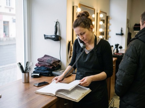 Kadeřnice zavírá salon, večerní světlo ve výloze